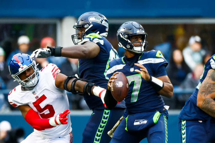 Seattle Seahawks quarterback Geno Smith (7) looks to pass as offensive tackle Charles Cross (67) backs against New York Giants defensive end Kayvon Thibodeaux (5) during the third quarter at Lumen Field.